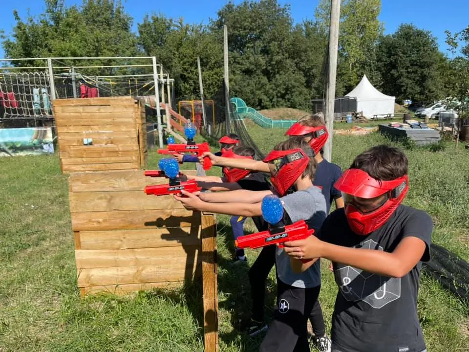 Enfants qui jouent au gellyball derrière une palissade